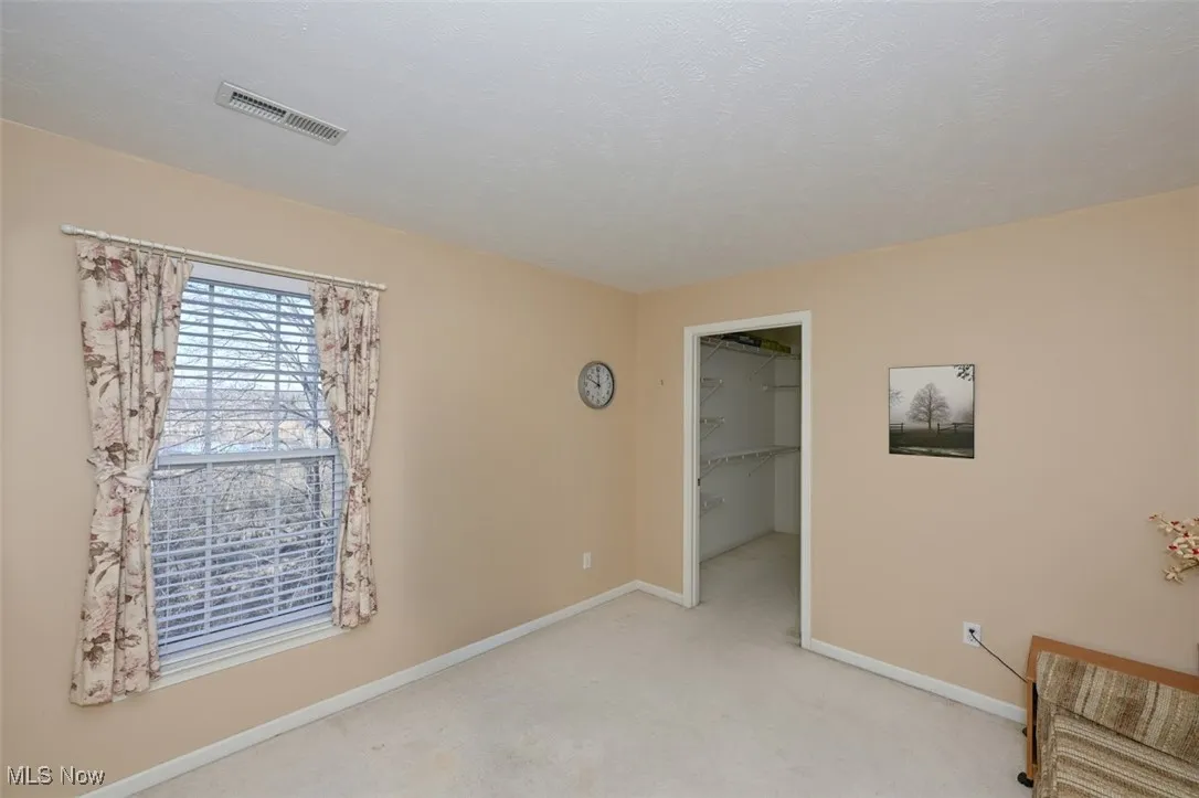 bedroom 3 with a walk in closet and carpet flooring