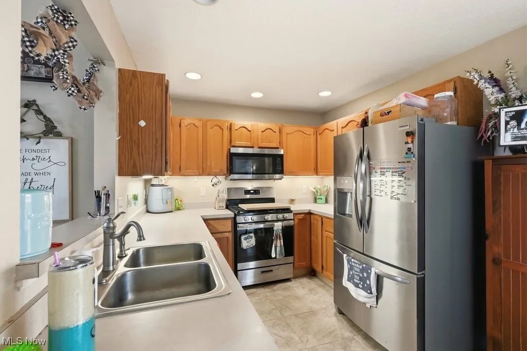 KITCHEN VIEW 1. STAINLESS APPLIANCES, CERAMIC FLOORING & NEUTRAL COUNTERTOPS.