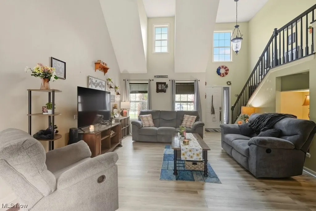 VAULTED LIVING ROOM WITH UPDATED VINYL FLOORING.