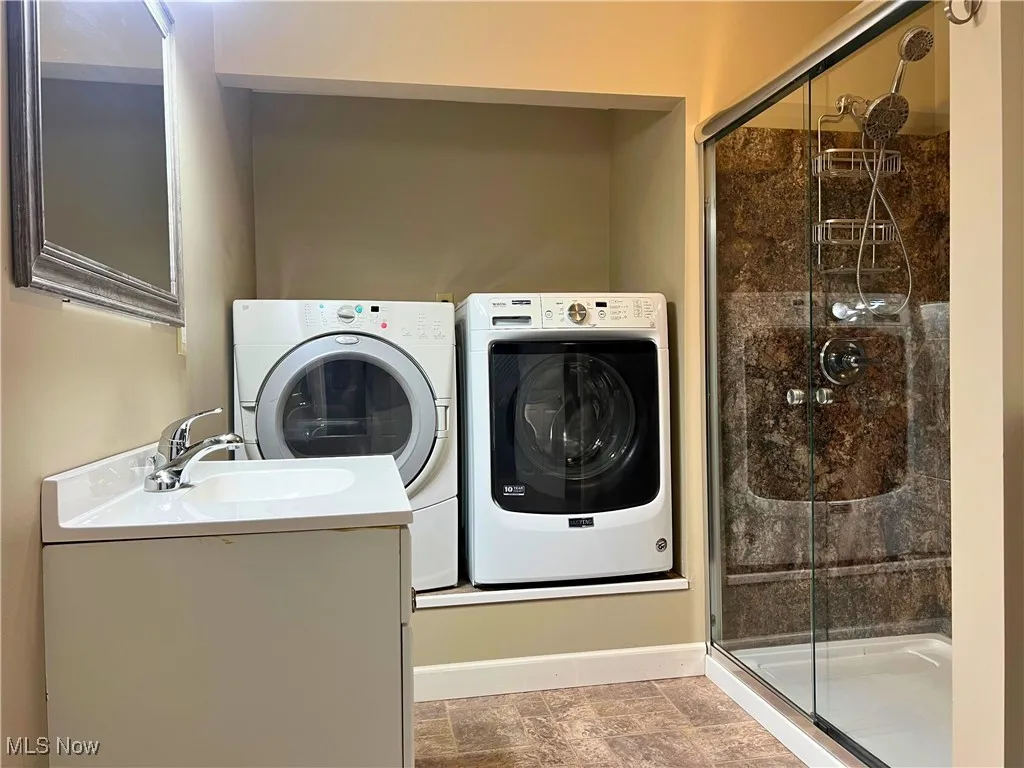 Laundry area with washer and clothes dryer and finished floors