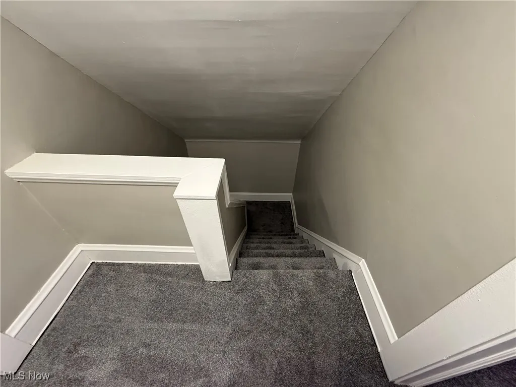 Staircase featuring carpet and baseboards