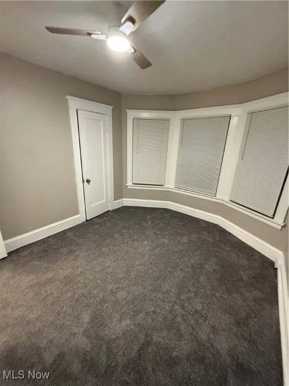 Unfurnished bedroom featuring carpet flooring and ceiling fan