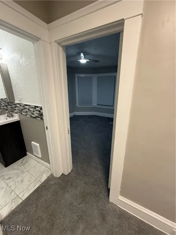 Hallway with marble look tiles and baseboards