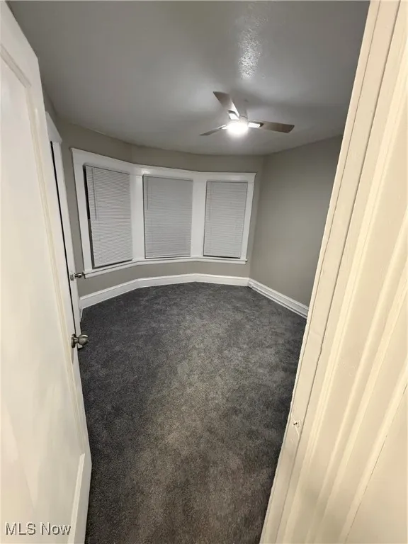 Unfurnished room featuring carpet flooring and a ceiling fan