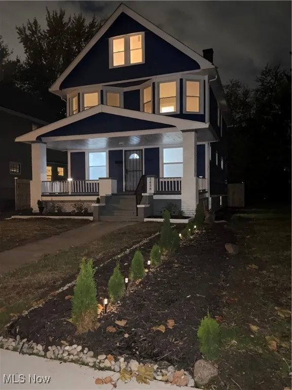 American foursquare style home featuring covered porch