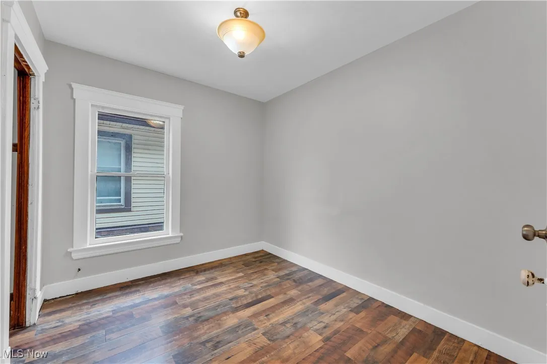 Empty room with dark wood finished floors and baseboards