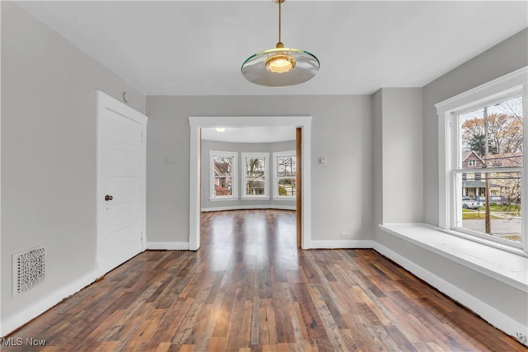 Unfurnished room with dark wood finished floors and baseboards