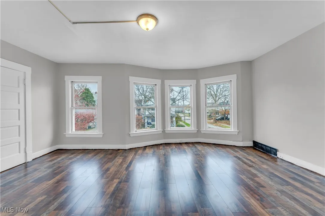 Spare room with dark wood-type flooring
