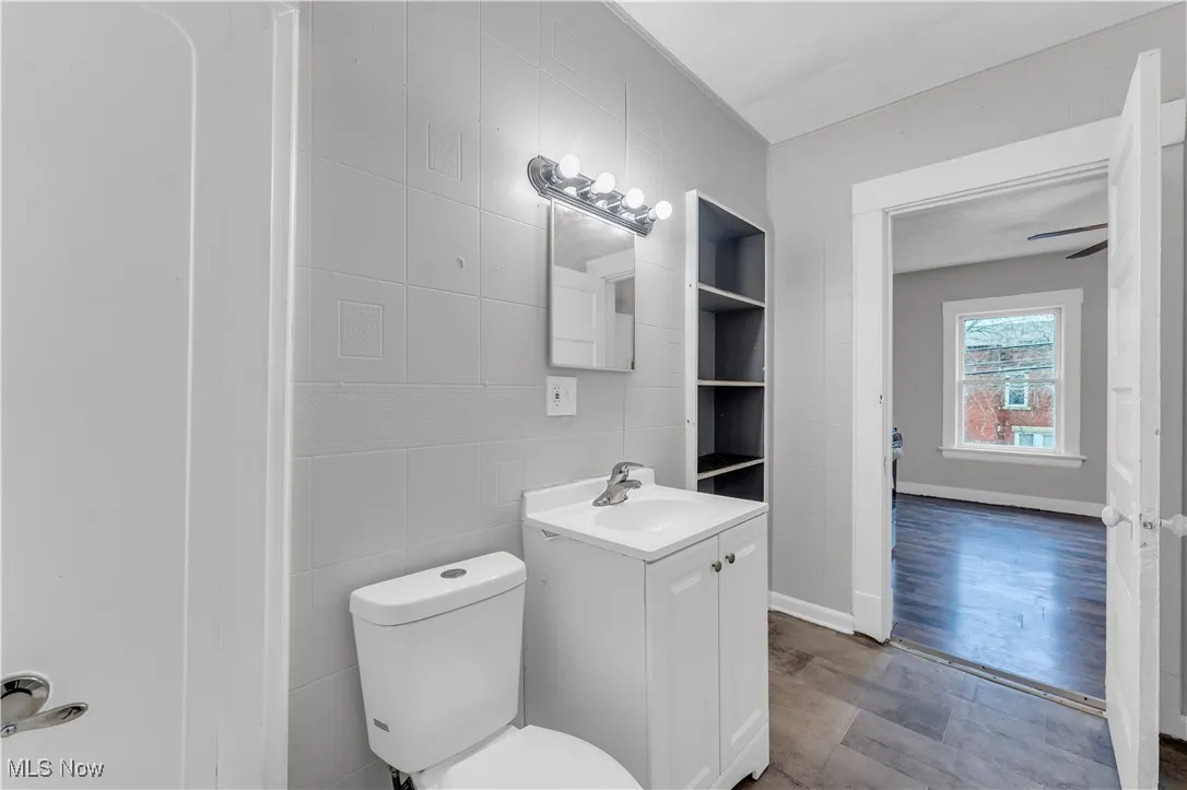 Half bathroom featuring vanity and tile walls