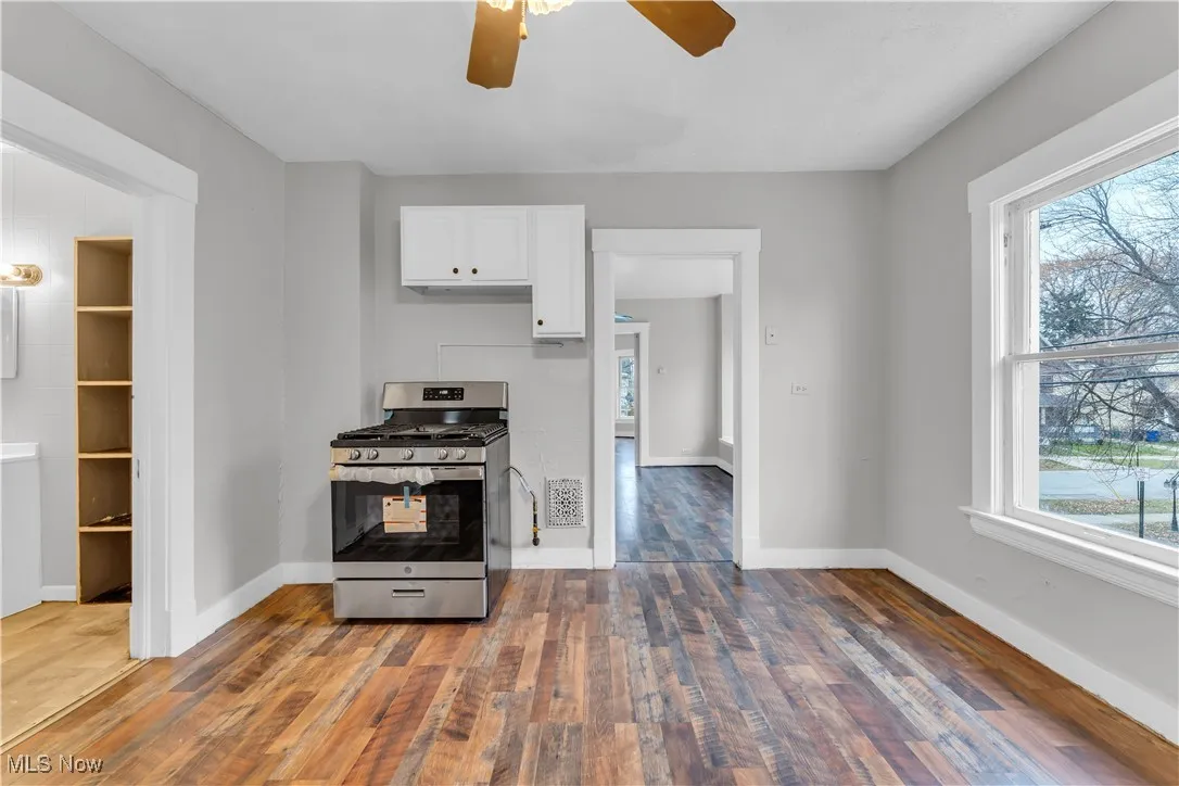 Kitchen featuring stainless steel range with gas cooktop, white cabinetry, plenty of natural light, and a ceiling fan