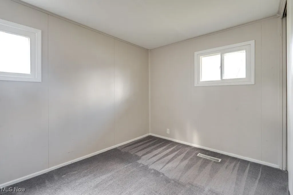 Spare room featuring carpet floors and a decorative wall
