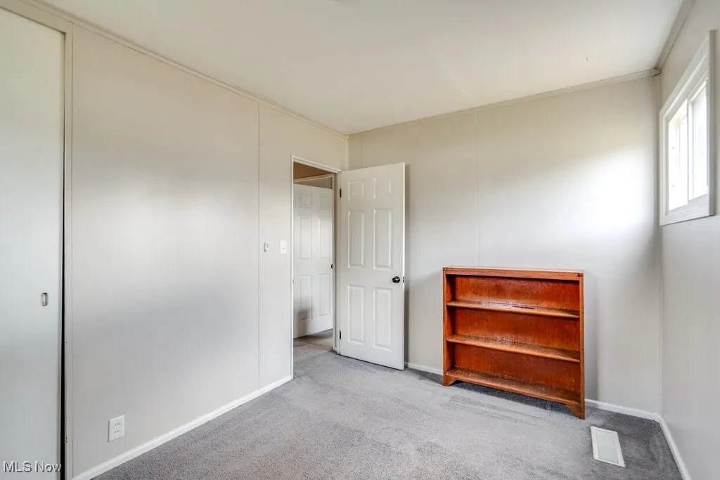 Unfurnished bedroom featuring carpet floors and baseboards