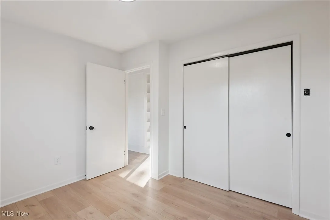 Unfurnished bedroom featuring light wood-type flooring and a closet