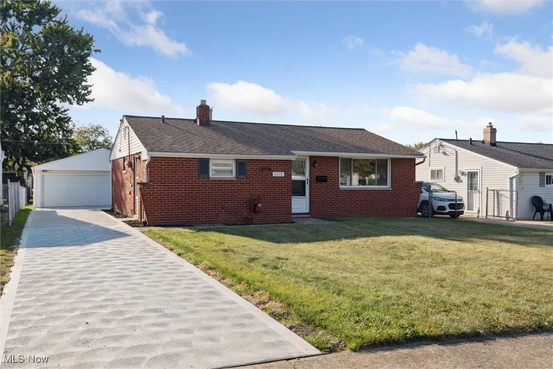 Ranch-style house with brick siding, a front lawn, a chimney, and an outdoor structure