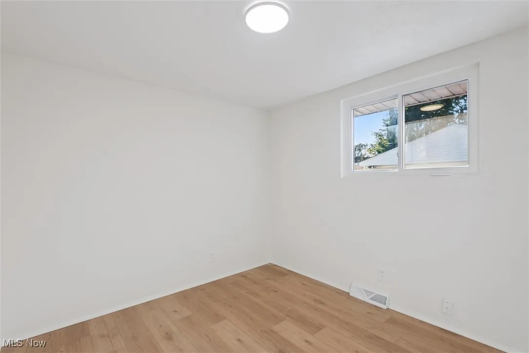 Empty room with light wood-type flooring and baseboards