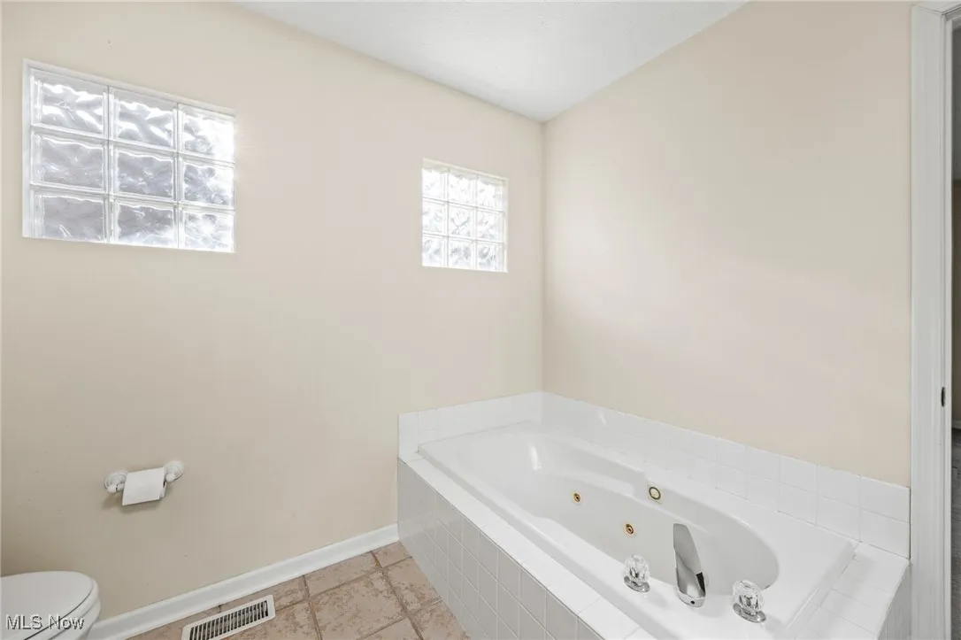Bathroom with a whirlpool tub and toilet