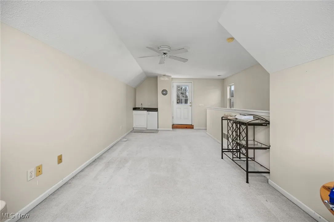 Bonus room featuring light carpet, ceiling fan, and lofted ceiling