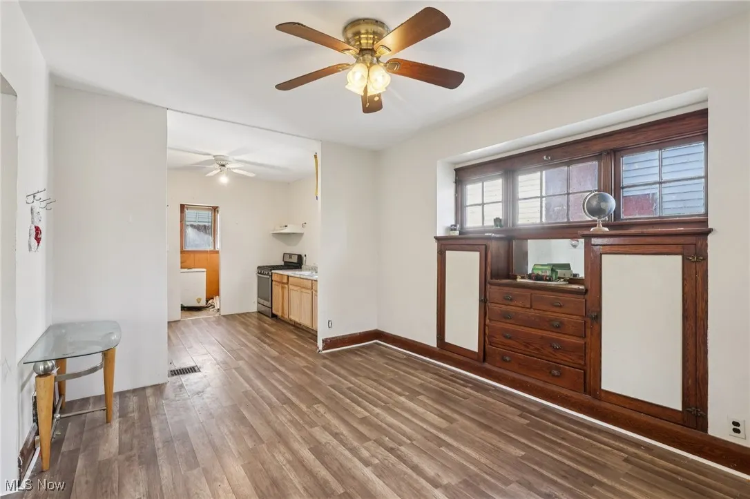 Unfurnished living room featuring dark wood finished floors and a ceiling fan