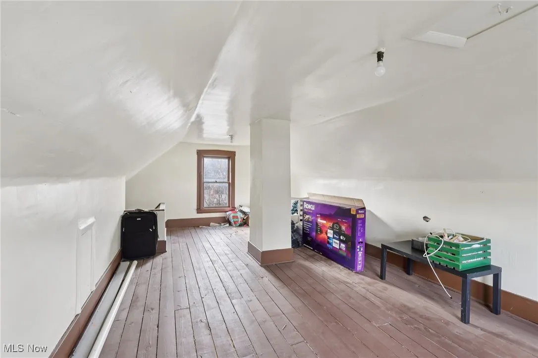 Recreation room featuring wood-type flooring and vaulted ceiling