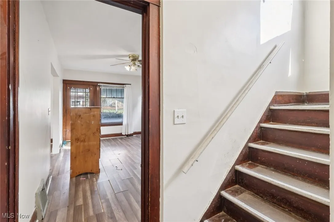 Stairway with hardwood / wood-style flooring and ceiling fan
