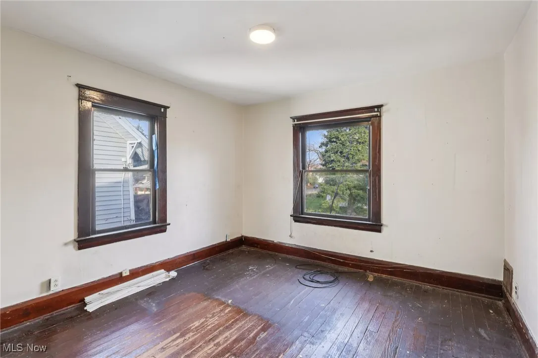 Spare room with baseboards and hardwood / wood-style flooring