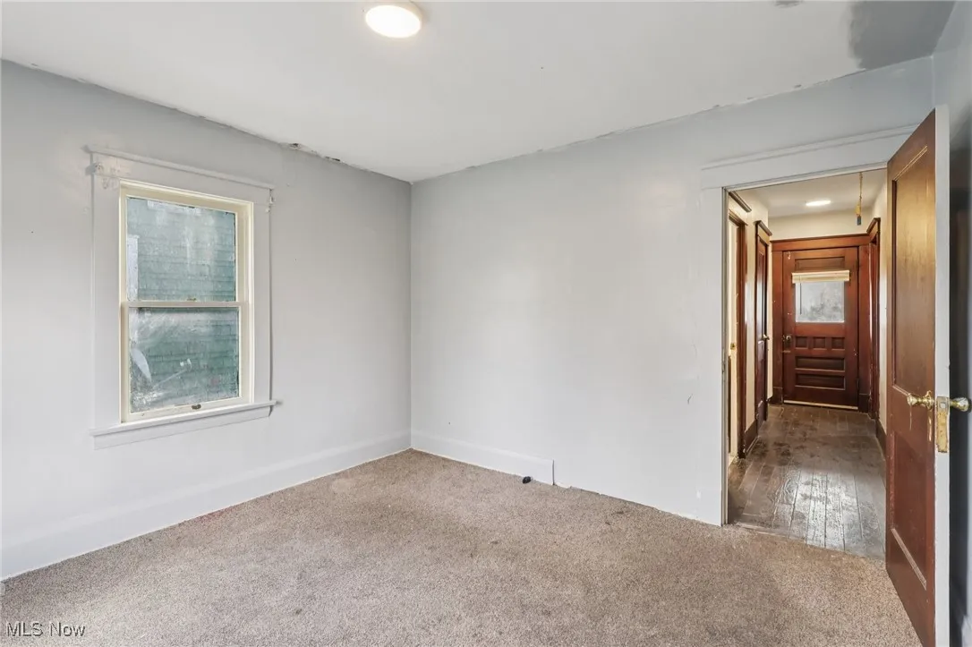 Empty room with carpet flooring and attic access