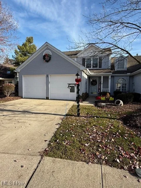 Traditional-style house featuring driveway, covered porch, and a garage