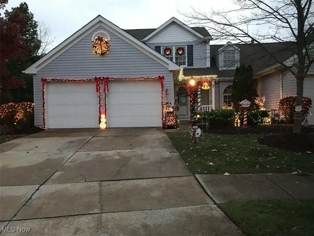 View of front of home with concrete driveway, a front lawn, and an attached garage