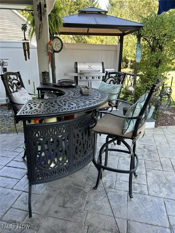 View of patio featuring a gazebo, a grill, and outdoor dining space