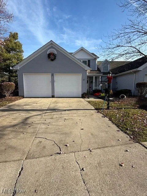 View of front of property with concrete driveway, a porch, and a garage