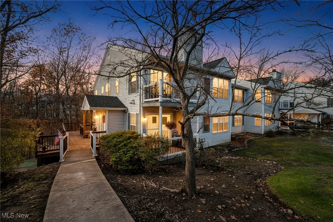 View of front of property with a balcony, a chimney, and a wooden deck
