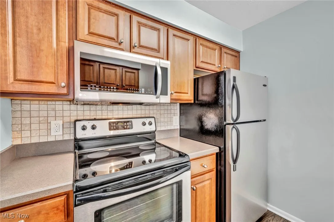 Kitchen featuring stainless steel appliances, light countertops, and tasteful backsplash