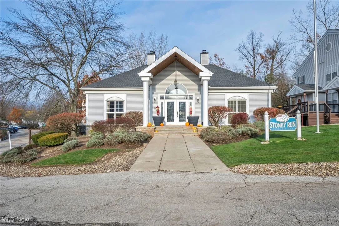 View of front facade featuring a chimney, french doors, a front yard, and a shingled roof