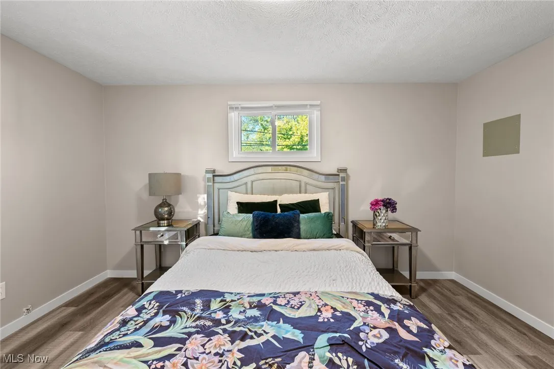 Bedroom with a textured ceiling and wood finished floors