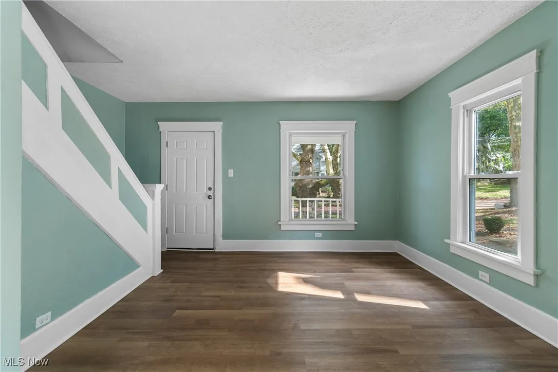 Foyer entrance featuring dark wood-type flooring and a textured ceiling