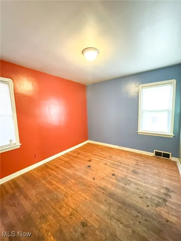 Spare room with baseboards and wood finished floors