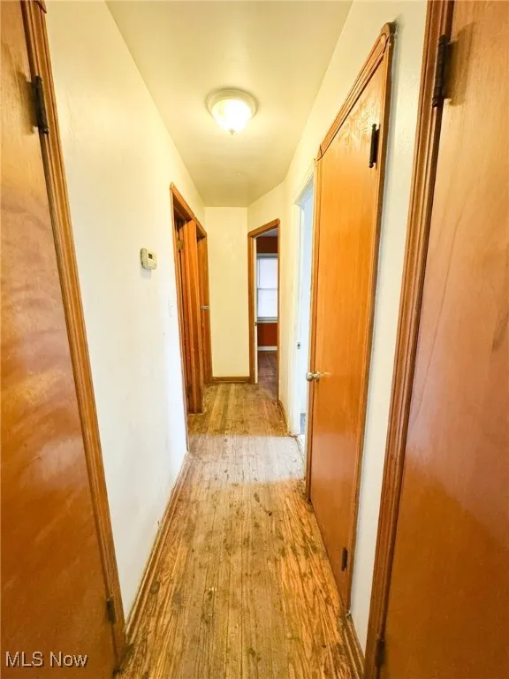 Hall with light wood finished floors and baseboards