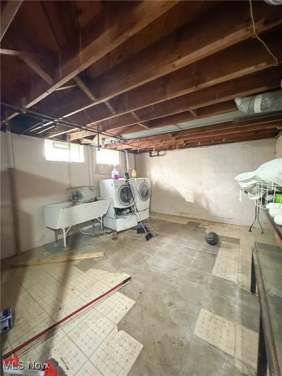 Below grade area with washing machine and clothes dryer and a sink