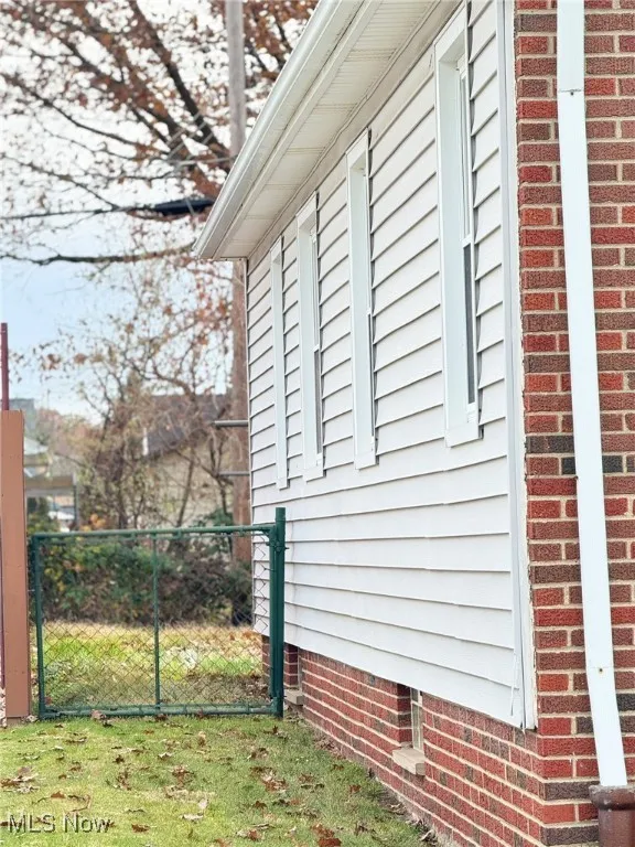 View of side of home with a gate