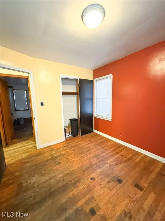 Unfurnished bedroom featuring hardwood / wood-style floors and a closet