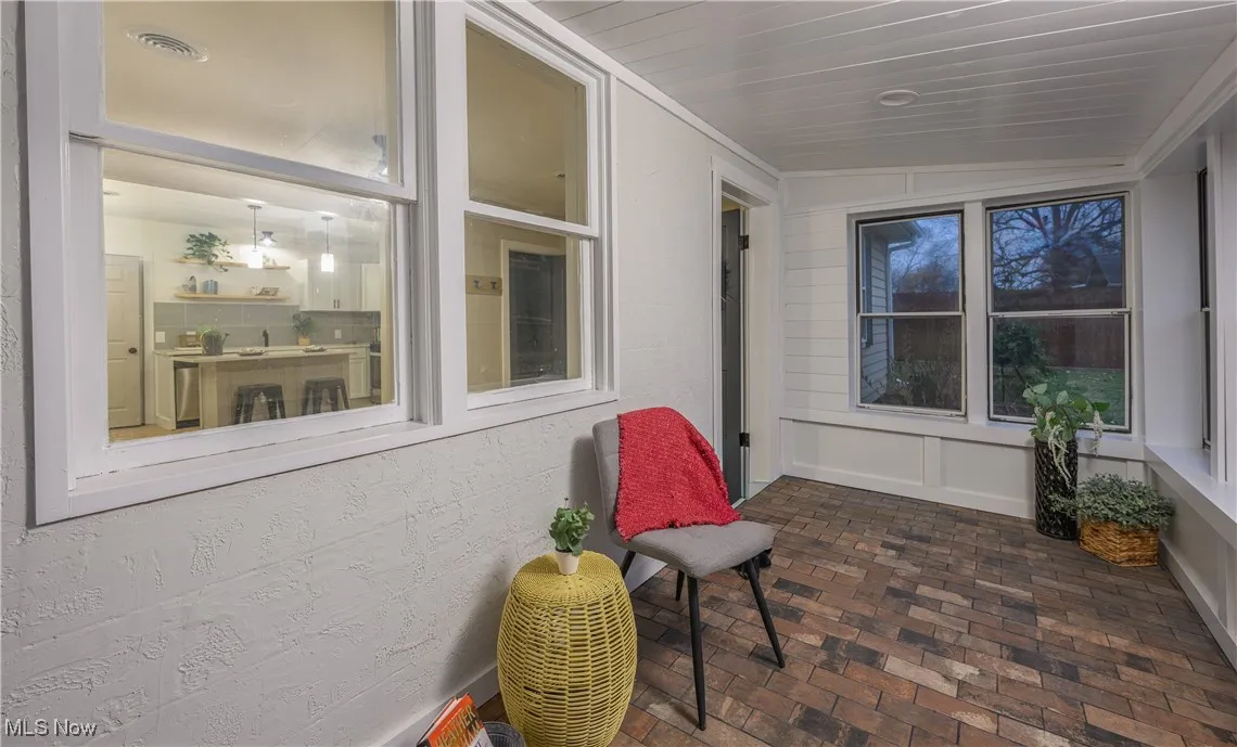 Sunroom / solarium with brick flooring and vaulted ceiling