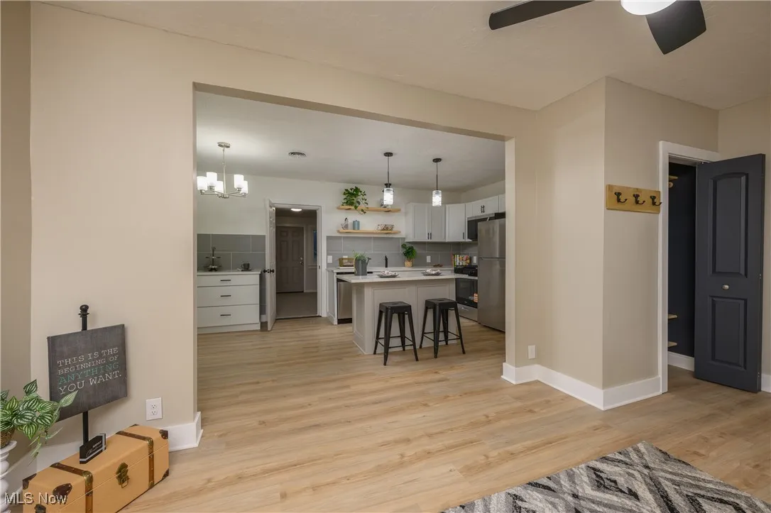 Living area featuring a chandelier, light wood finished floors, and ceiling fan