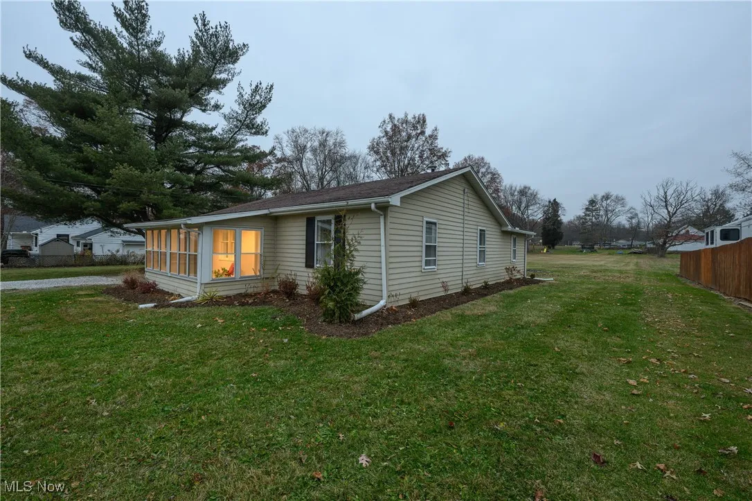 View of property exterior with a sunroom