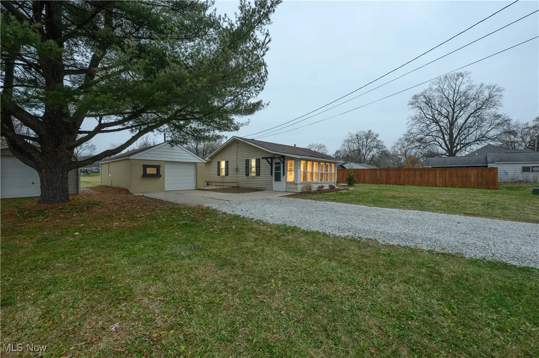 View of front of house with driveway, a garage, and a patio