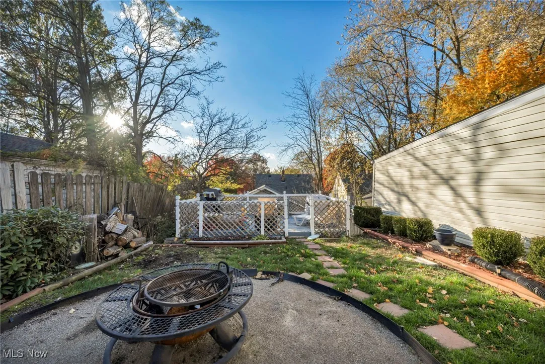 View of yard featuring a fire pit, a gate, and a wooden deck