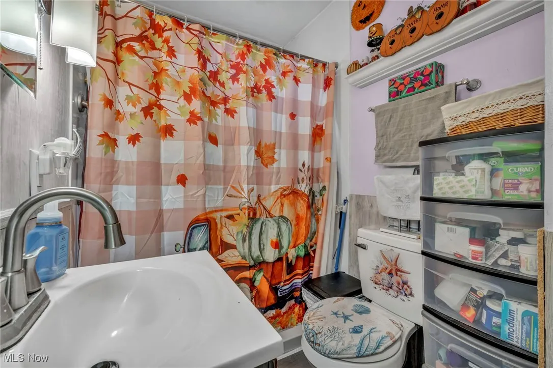 Bathroom featuring toilet and curtained shower