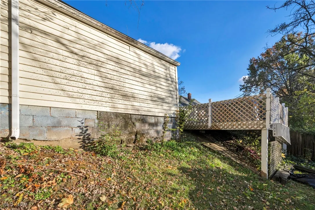 View of property exterior with a wooden deck