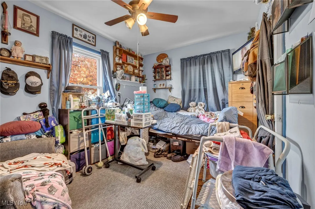 Carpeted bedroom featuring ceiling fan