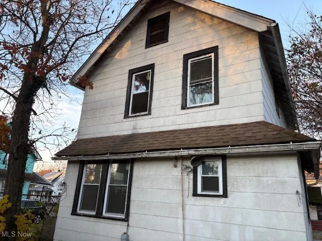 View of side of property featuring roof with shingles