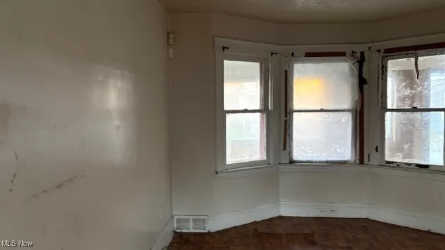 Unfurnished room with baseboards and a textured ceiling